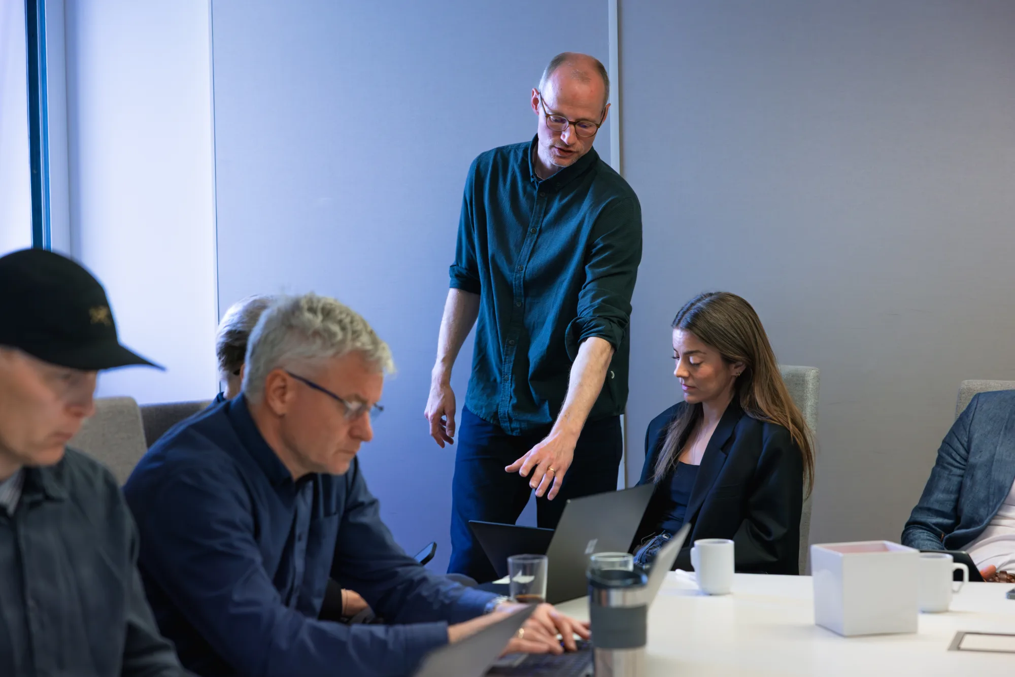 Trainer coacht een deelnemer aan de laptop tijdens een werksessie bij Stokke